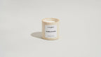 Bougie parfumée Cannelya dans un pot beige texturé, étiquette Vanille Ambrée