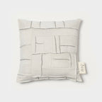 Coussin carré ivoire à motifs géométriques en relief et surpiqûres, face avant.