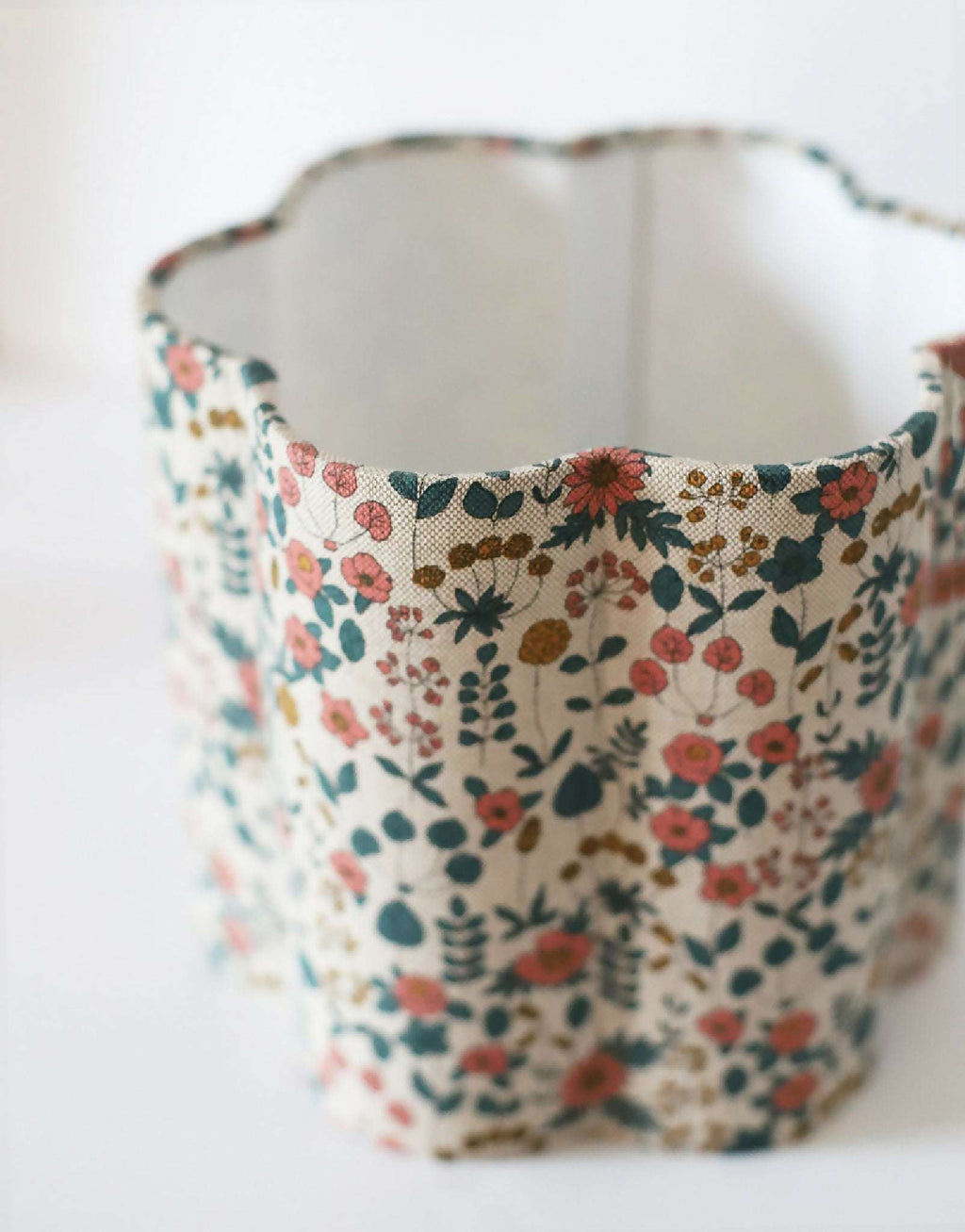 Abat-jour en tissu fleuri beige, vue intérieure sur le tissu et les coutures.