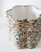 Abat-jour en tissu fleuri beige, vue intérieure sur le tissu et les coutures.