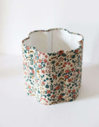 Abat-jour cylindrique en tissu beige fleuri, vue de profil.