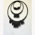 Décoration murale XXL noire en perles et franges, vue de face légèrement en angle