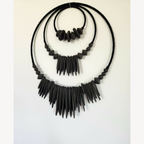 Décoration murale XXL noire en perles et franges, vue de face légèrement en angle