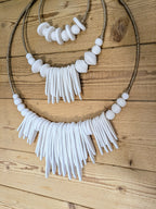 Décoration murale avec perles blanches, cordon brun et franges en demi-cercle