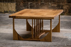 Table basse en bois clair vue de trois quarts, plateau rectangulaire et structure ajourée
