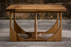 Table basse en bois clair avec large ouverture semi-circulaire sous le plateau