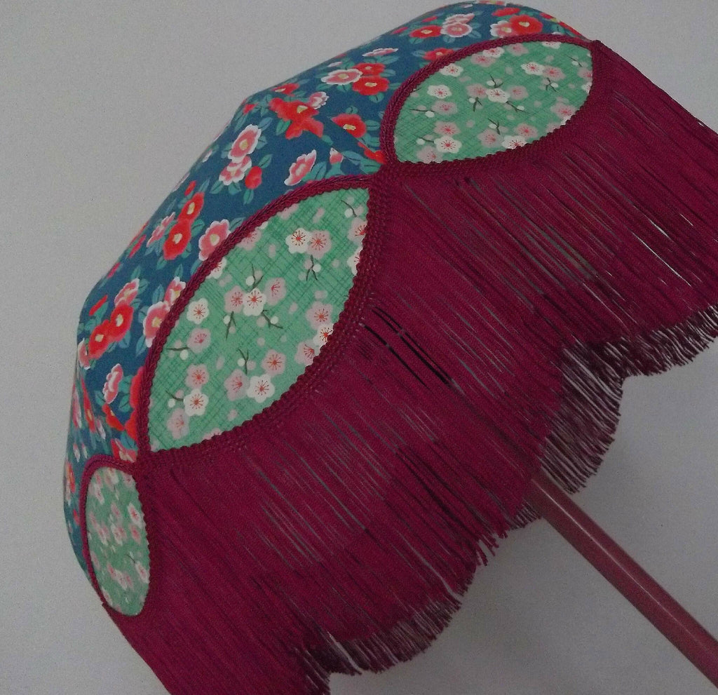Abat-jour rétro papier japonais franges bordeaux, panneaux verts à motifs fleuris.