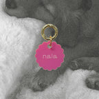 Médaille Bloom en émail rose, anneau doré, inscription « nala » en face.
