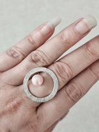 Bague Atoll sur main, cabochon perle rose nacrée dans cercle texturé argenté
