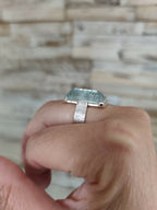 Bague en topaze bleu clair rectangulaire sur doigt, vue latérale, argent.