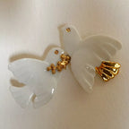 Broche colombes blanches avec détails dorés, attache à l’arrière.
