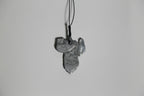 Pendentif argenté-gris en forme de feuille, détail de texture, sur cordon.