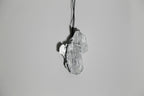 Pendentif gris argenté en forme de feuille, vue de dessus, sur cordon.