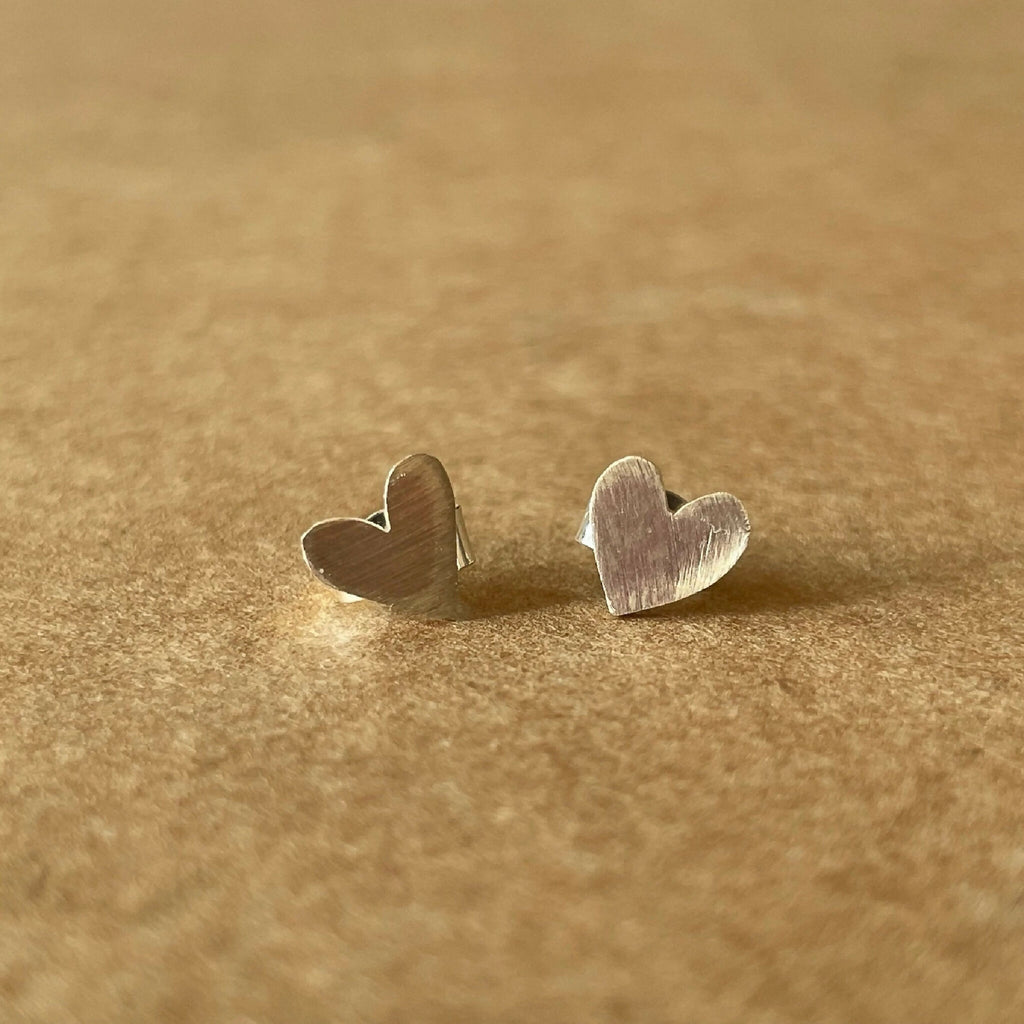 Puces d’oreilles cœur, paire de petits clous au premier plan