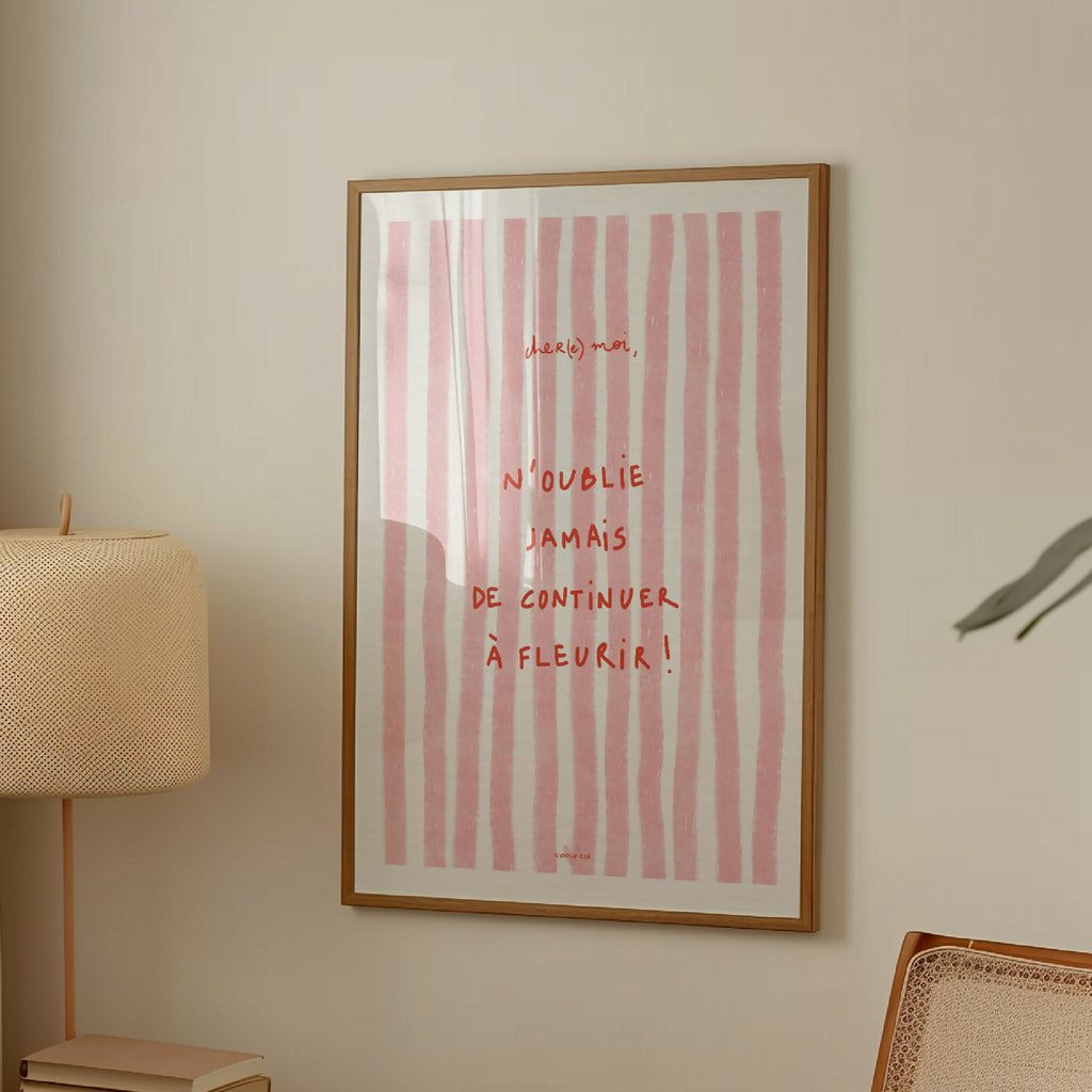 Affiche encadrée rectangulaire aux rayures roses et texte manuscrit « N’oublie jamais »