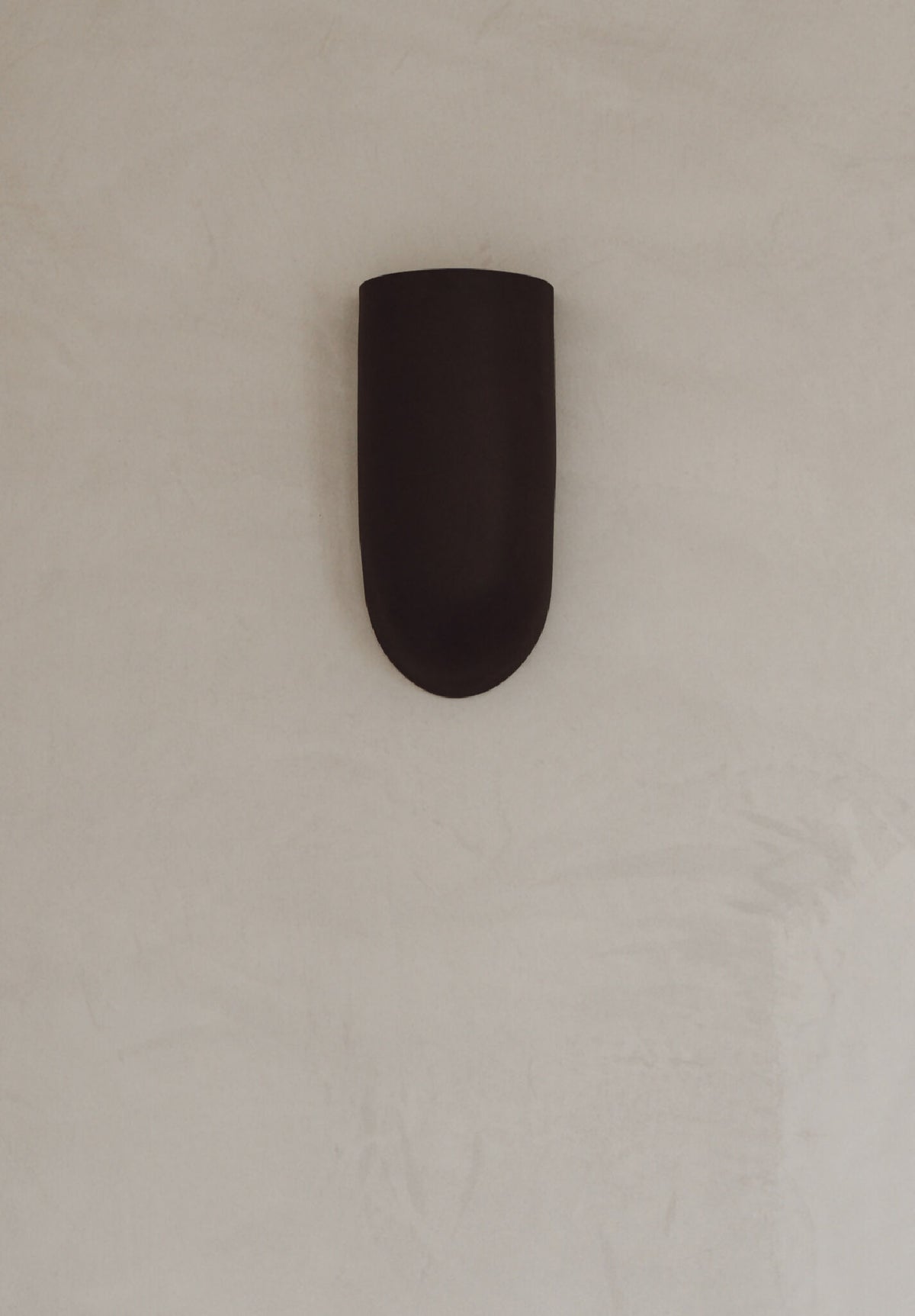 Applique murale en céramique marron, vue rapprochée, éclairage intégré vers le bas.