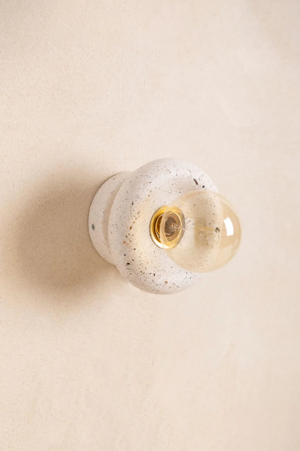 Applique murale NORA ronde beige à effet sablé, douille laiton et verre transparent