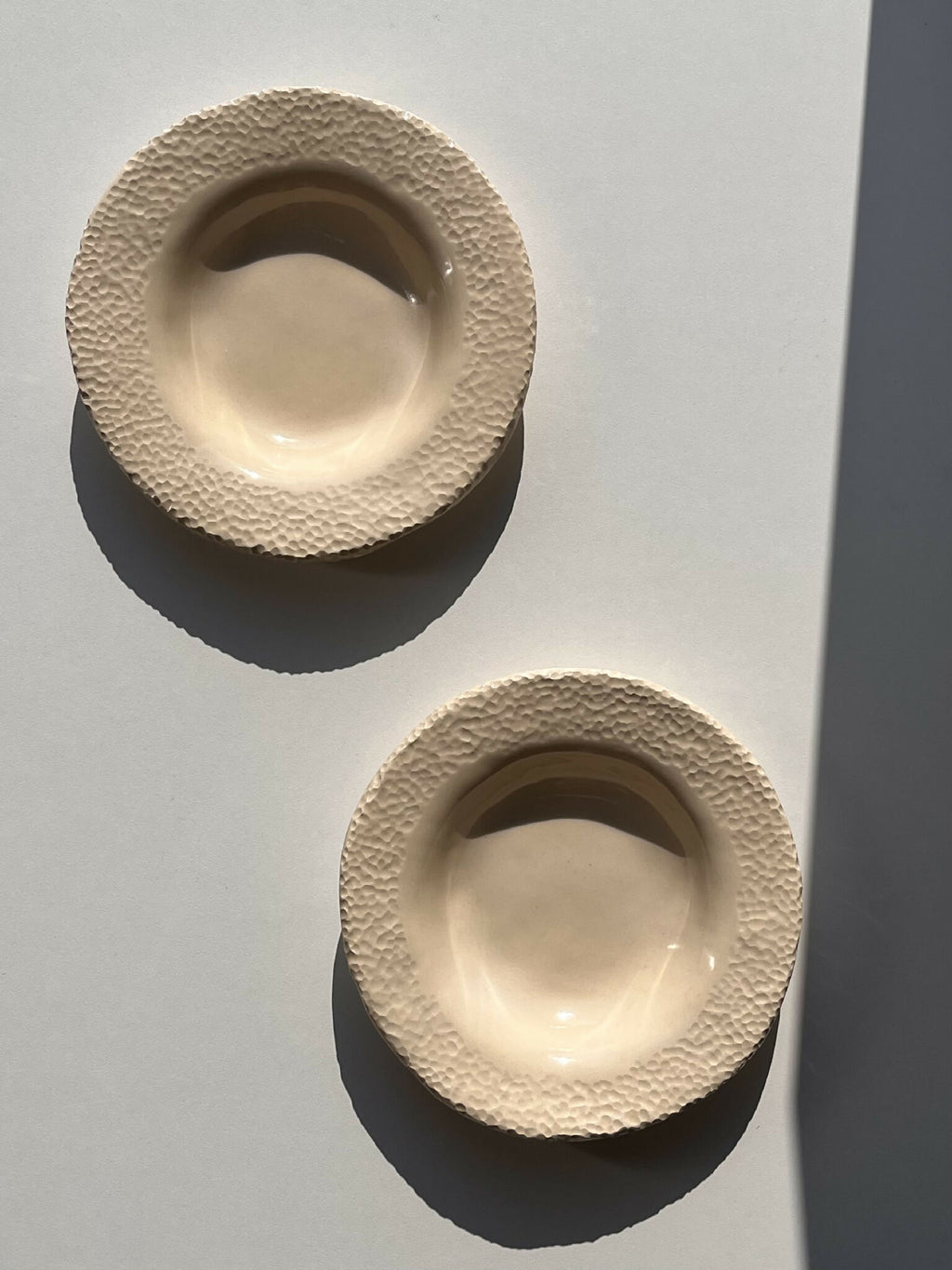 Deux assiettes beige texturées, intérieur lisse, vue de dessus
