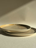 Assiette sable en céramique beige, bord doré, vue de dessus avec assiette superposée