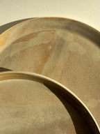 Assiette sable beige, gros plan de la bordure et du dessous texturé, chevauchement