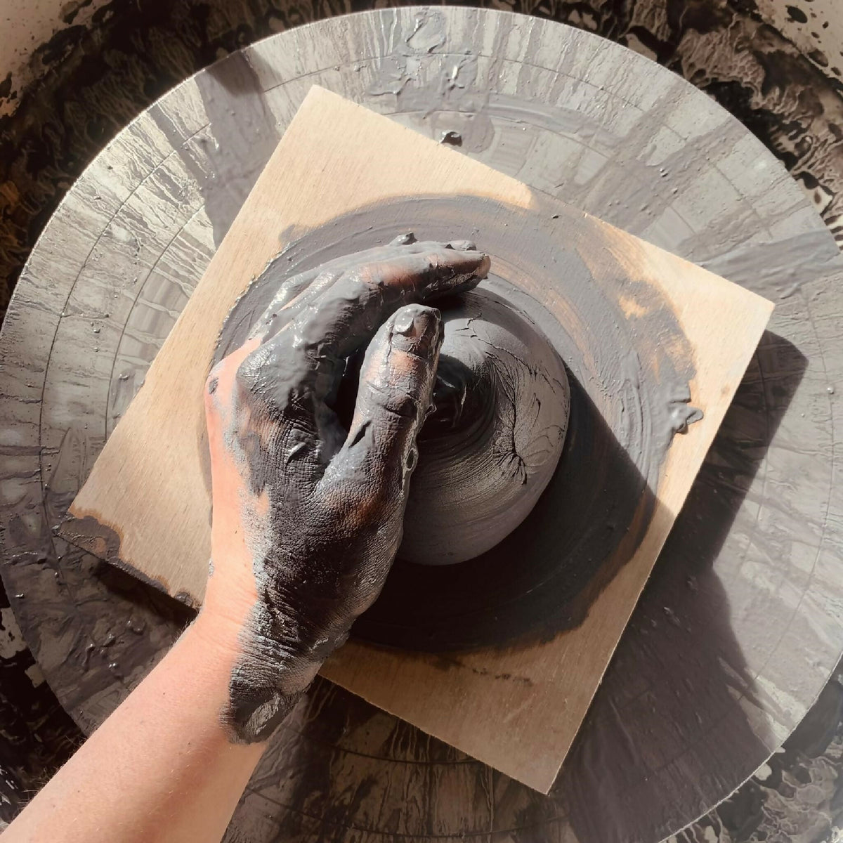 Mug en céramique en cours de finition, intérieur peint avec une main gantée