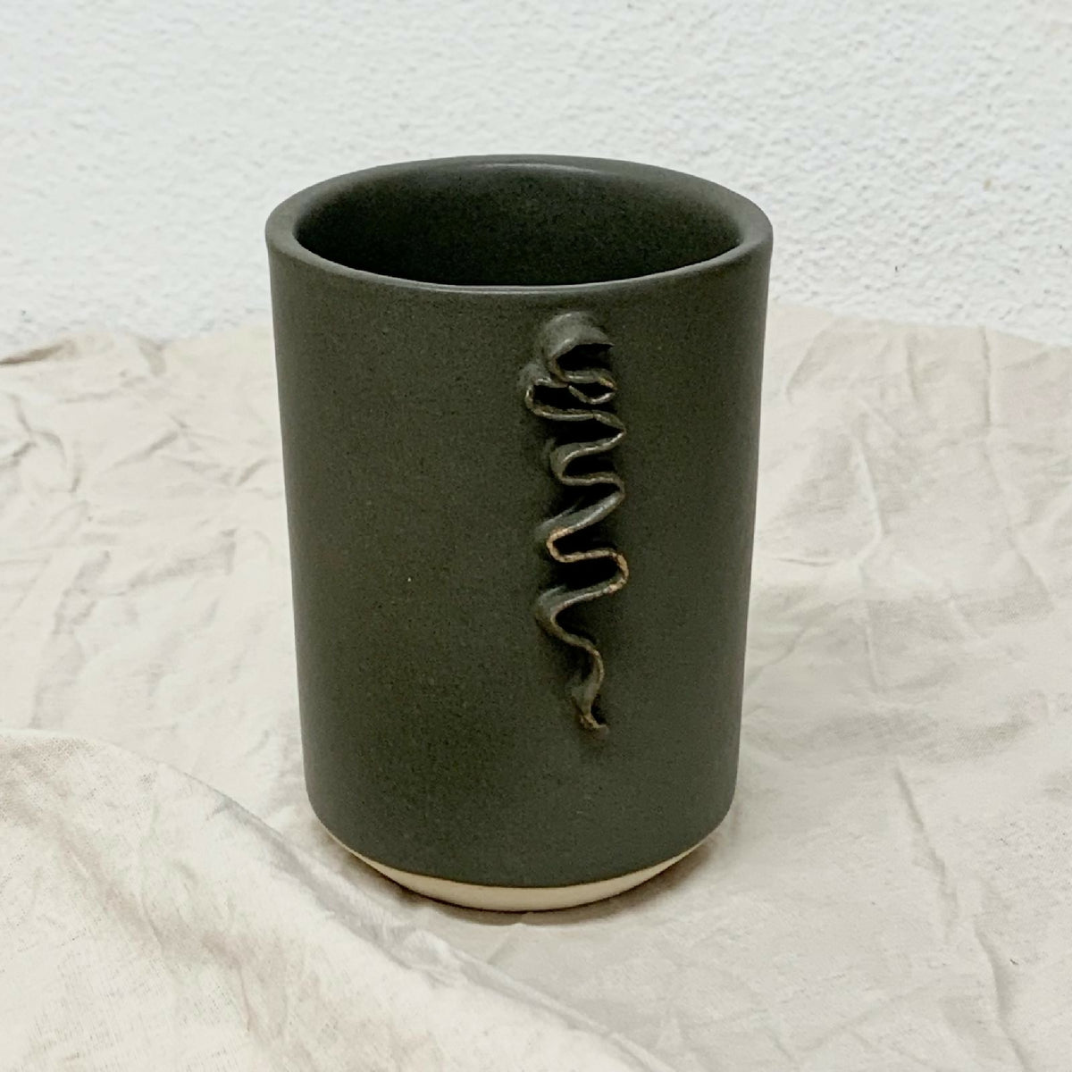 Mug en céramique kaki avec motif froufrou en relief sur la façade