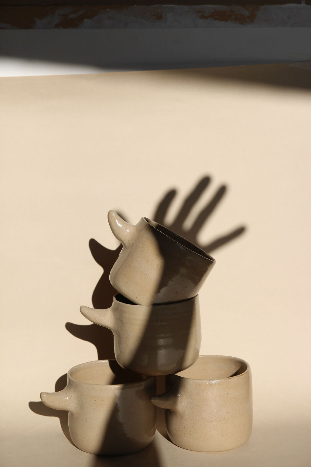 Tasses en forme de cornes, beige et brun foncé, empilées en trio