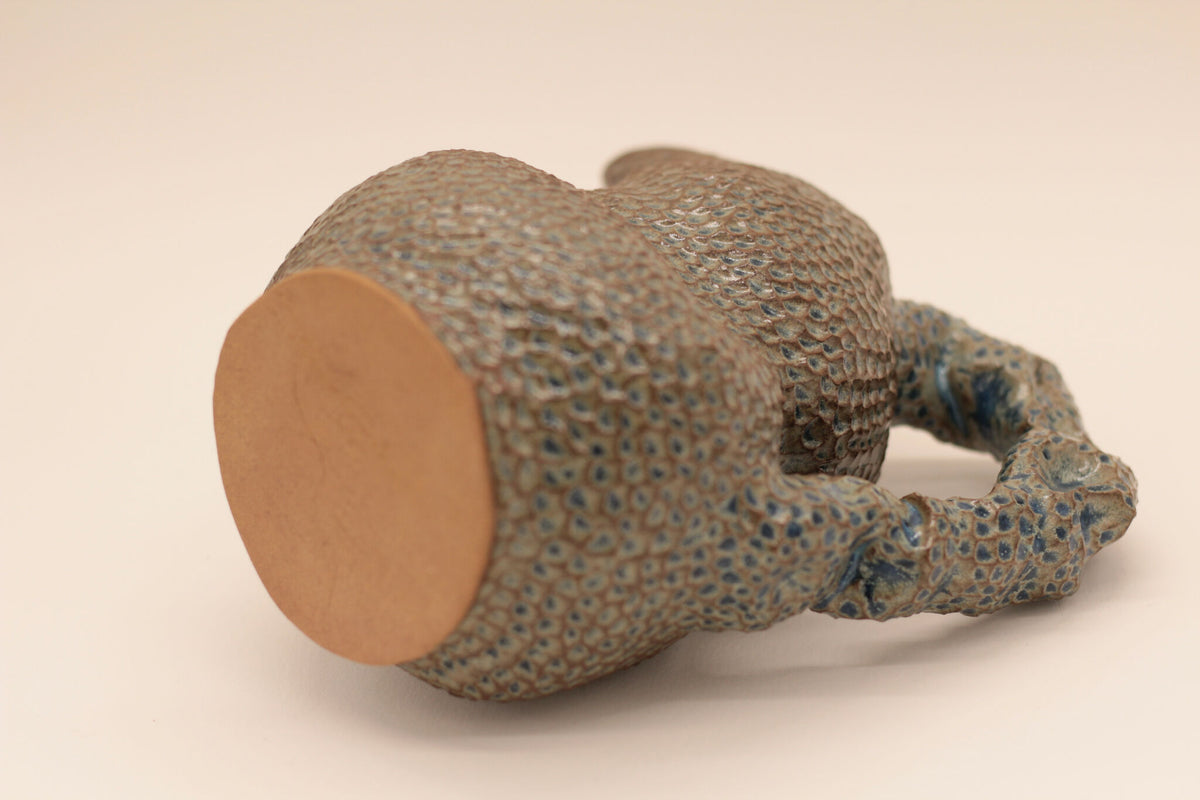 Pichet en forme de canard en céramique bleu moucheté, vue latérale de l’ouverture.