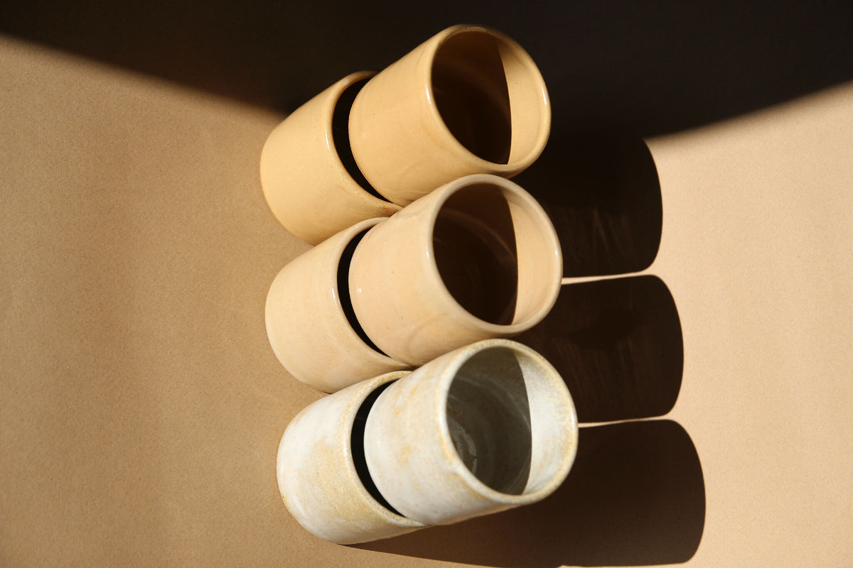 3 tasses à expresso en céramique beige et nacré, empilées, vues de dessus.