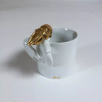 Tasse blanche avec homard doré, anse sculptée en forme de homard
