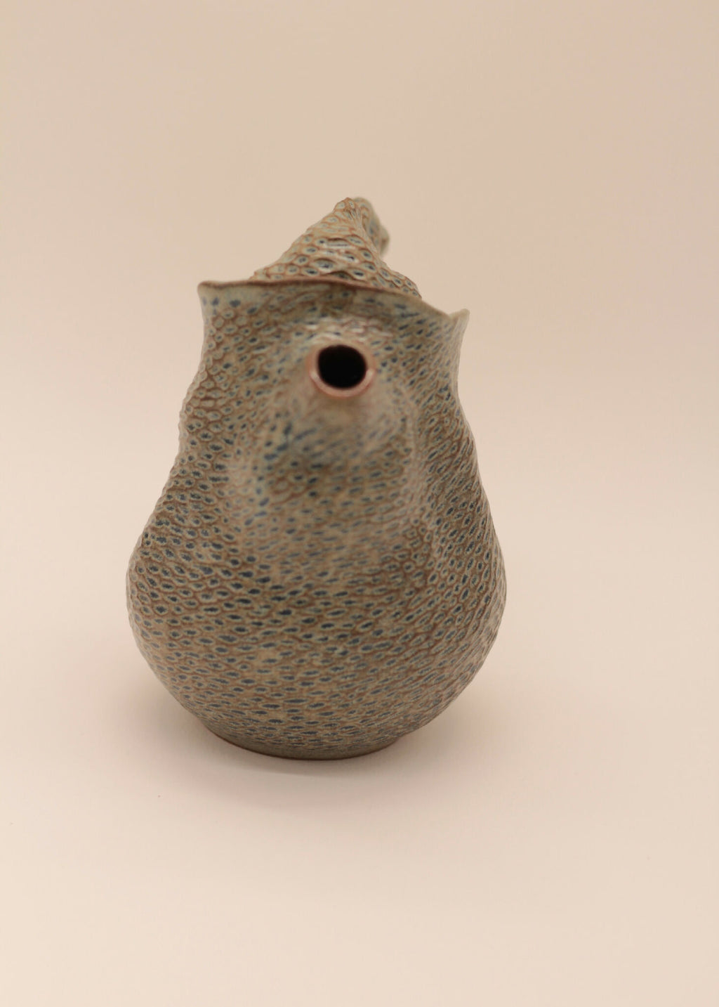 Théière en céramique grise à texture, vue de dessus avec trou de versement
