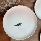 Assiette à dessert en porcelaine blanche, bord festonné, petit oiseau noir au centre