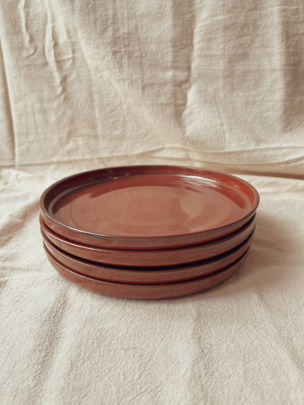 Pile d’assiettes céramique rouge bordeaux, bord sombre, style classique Algue