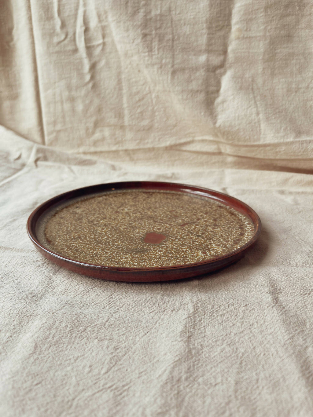Assiette ronde en céramique beige moucheté, liseré bordeaux, style classique Algue