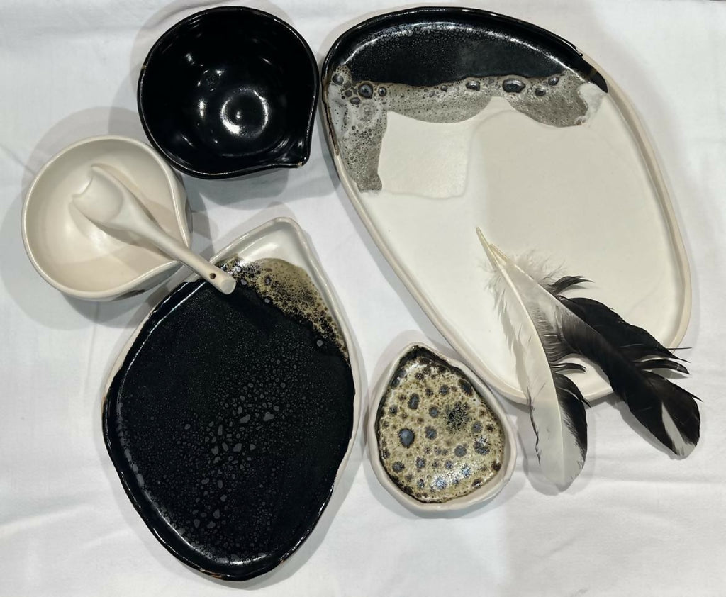 Ensemble de grandes assiettes ovales en céramique, noir, blanc et beige, motif éclaboussé