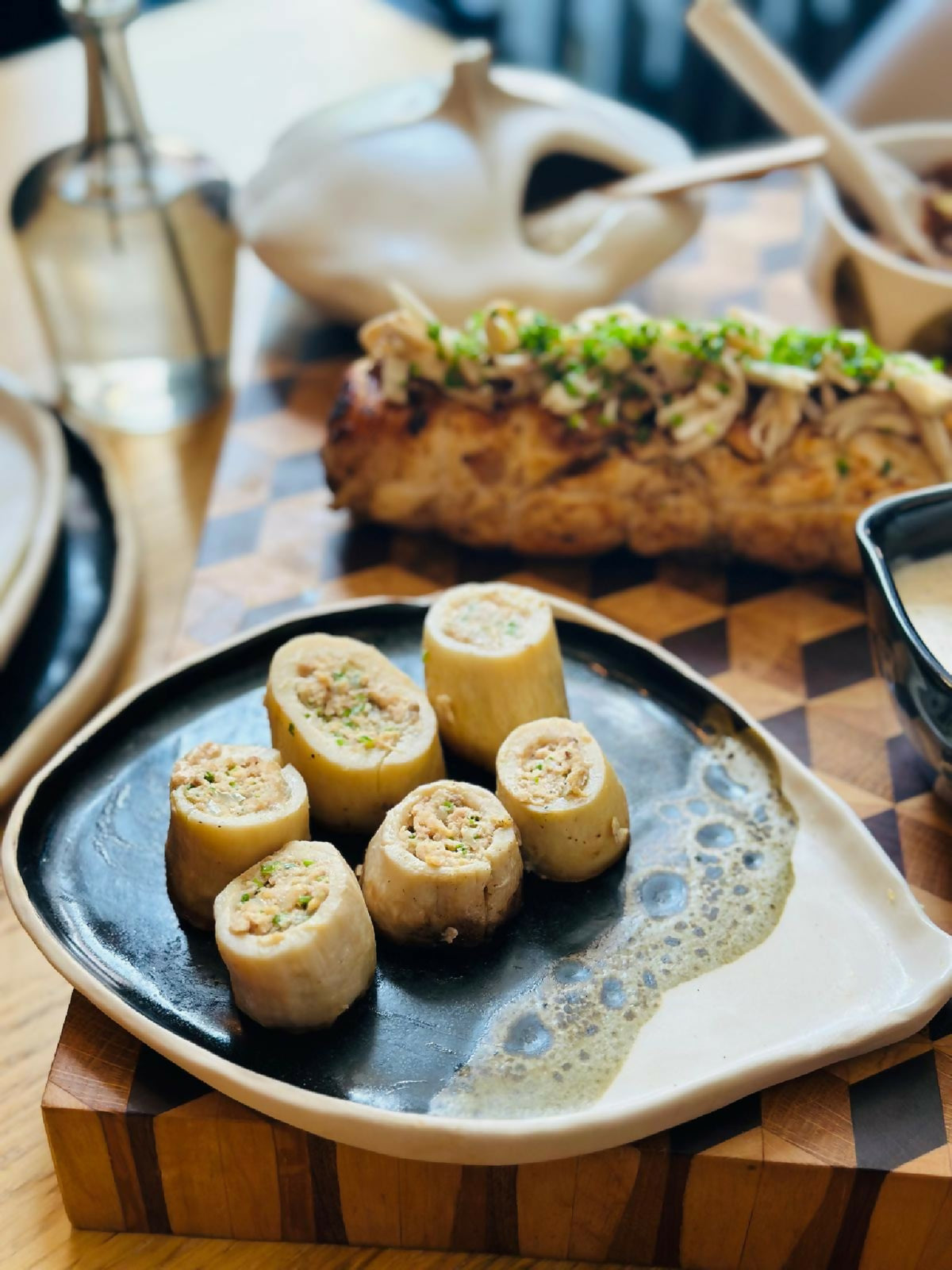 Petite assiette BT noir bord blanc, rondelles de pain aux herbes, sauce en fond clair