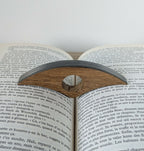 Support de lecture marqueté anthracite et paille sur livre ouvert, trou central