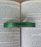 Marque-page en bois et incrustation verte, vu de près sur un livre.