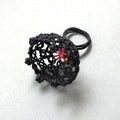Bague noire en résille tressée, motif étoile rouge au centre