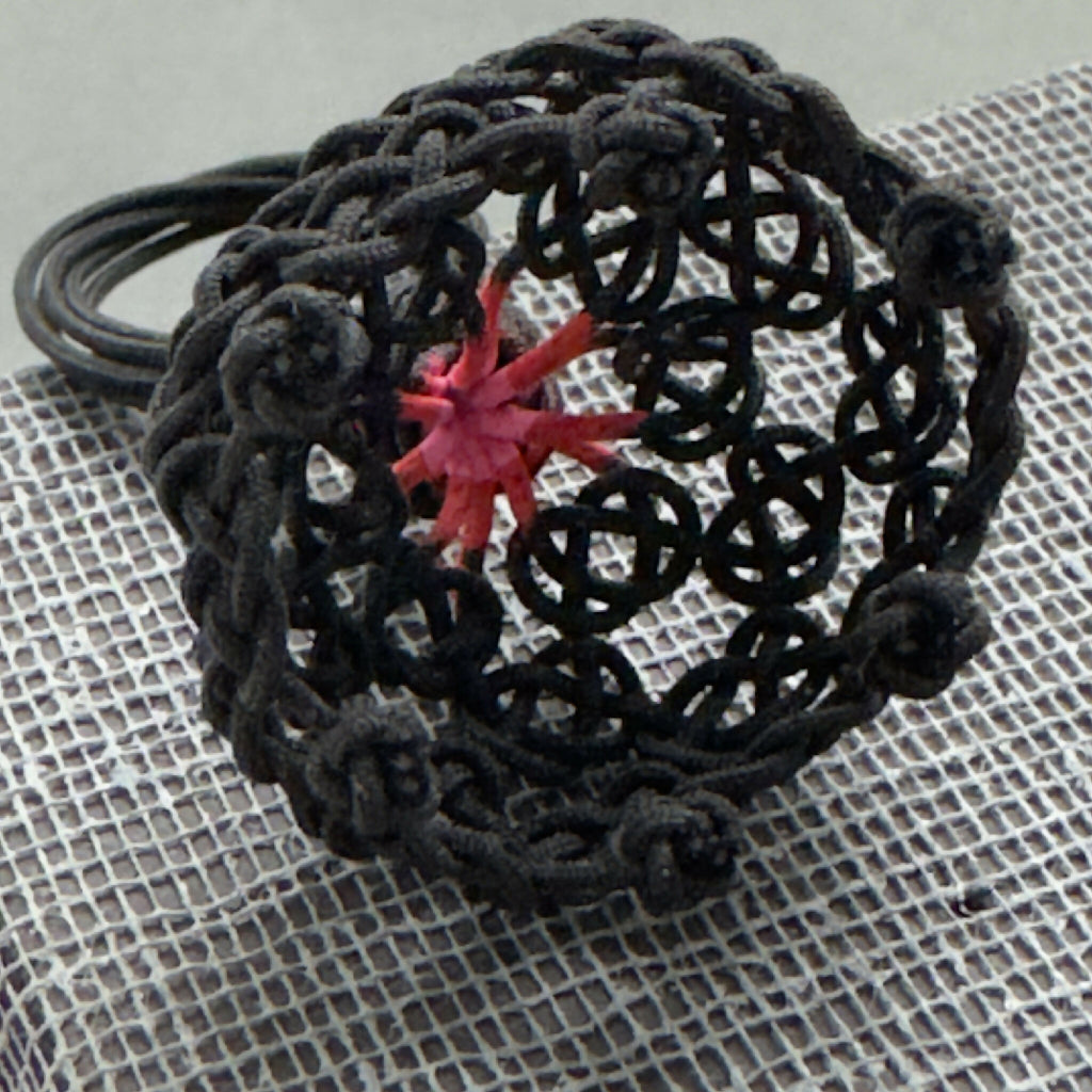 Bague noire résille, gros plan sur étoile rouge centrale