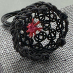 Bague noire résille, gros plan sur étoile rouge centrale