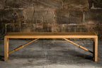 Banc en bois clair vu de dessous : renforts en bois en X sous le plateau.
