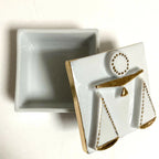 Boîte à bijoux en porcelaine blanche, motif balance doré, vue de côté du couvercle.