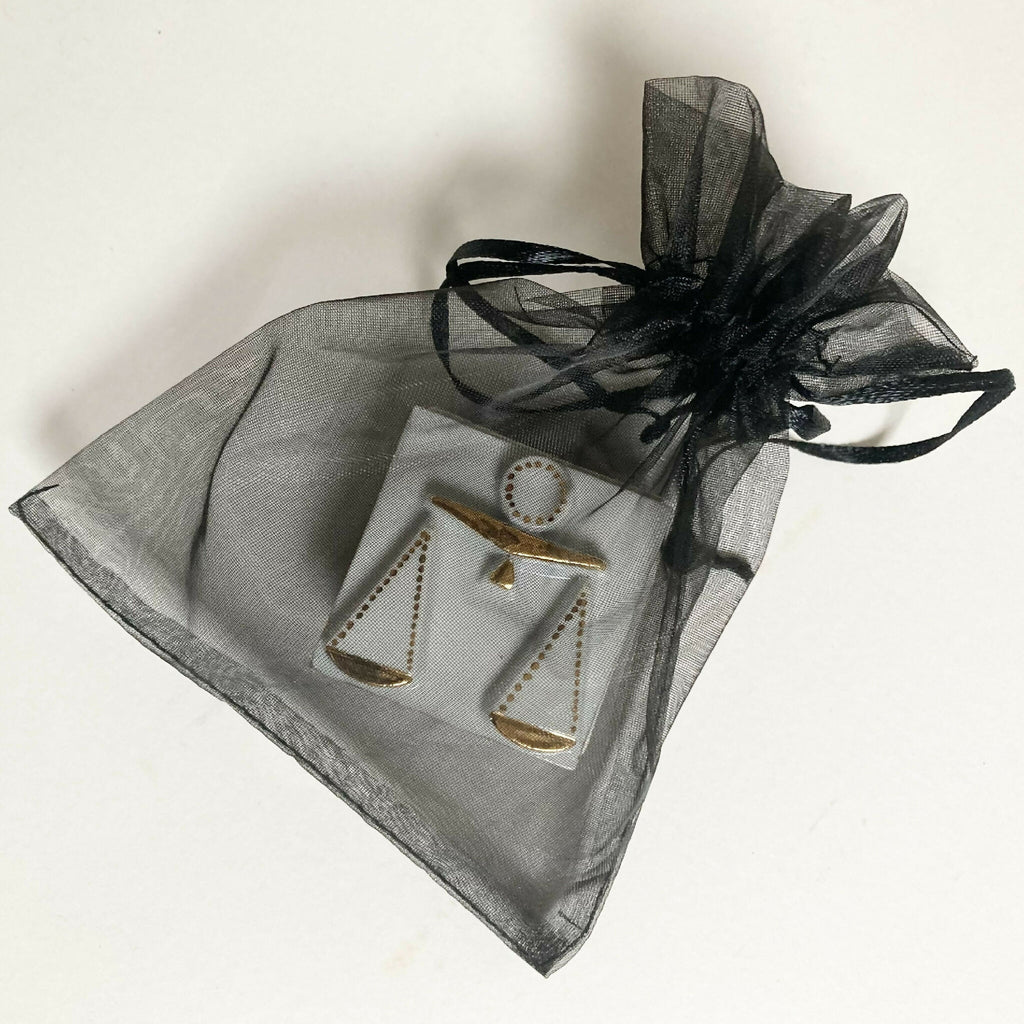Boîte à bijoux en porcelaine blanche avec ruban organza noir, décor balances dorées.