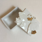 Boîte à bijoux blanche avec figurine de colombe laquée et détails dorés.