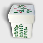 Boîte à bijoux en porcelaine blanche, couvercle floral rose et vert.