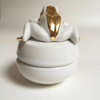 Boîte à bijoux grenouille blanche, couvercle ouvert vers l’arrière, finition dorée brillante.