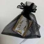 Boîte à bijoux poisson blanche, emballée dans un sachet organza noir avec rubans dorés