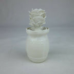 Vase en céramique blanc, forme cylindrique avec fleurs en relief sur le dessus.
