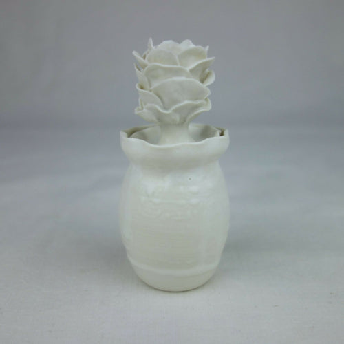 Vase en céramique blanc, forme cylindrique avec fleurs en relief sur le dessus.
